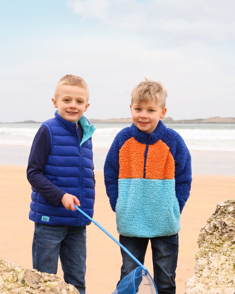 Navy Blue Orange coloured Lighthouse Childrens Caden Fleece on beach background 