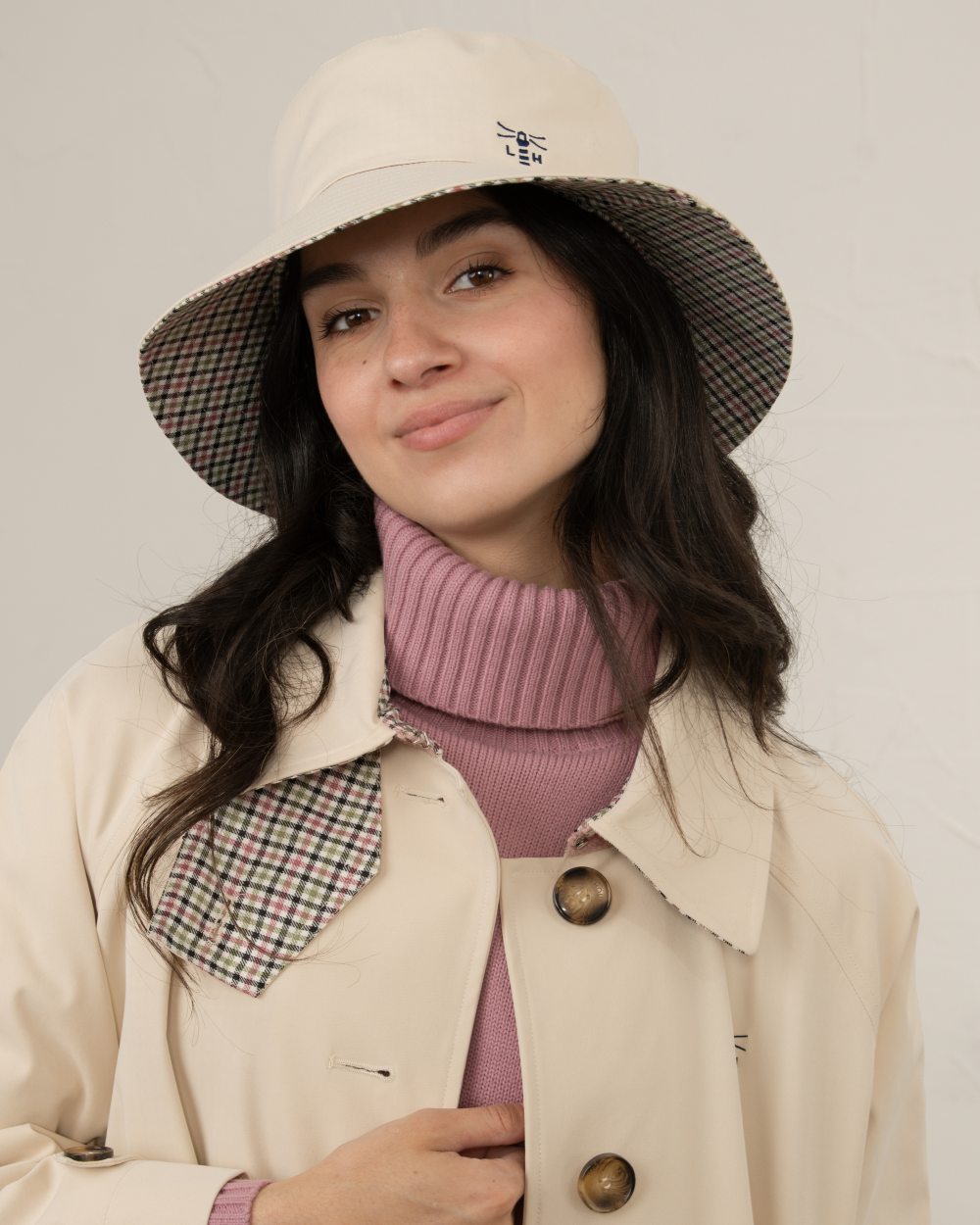 Stone coloured Lighthouse Edie Reversible Rain Hat on wall background 