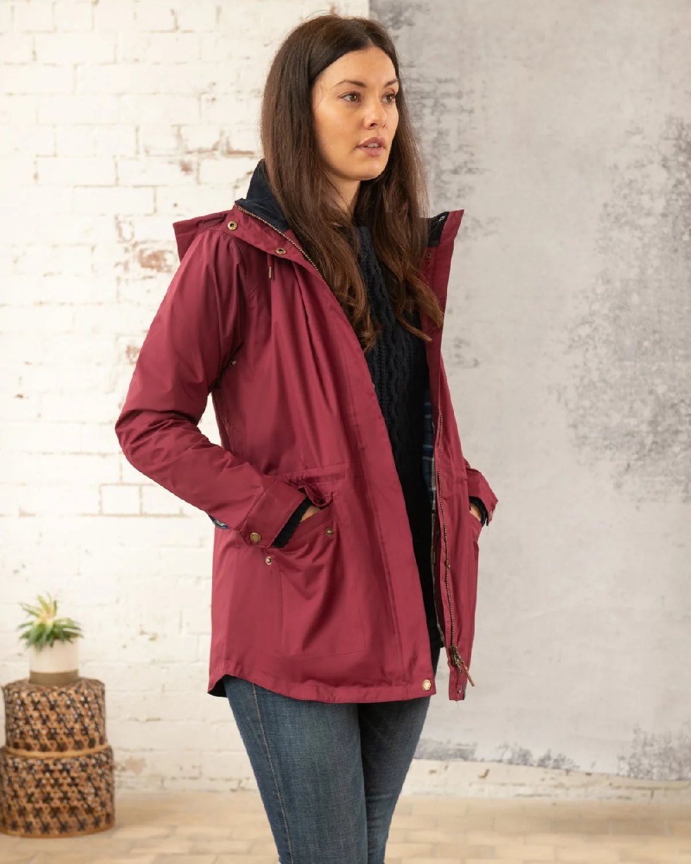 Berry coloured Lighthouse Kendal Waterproof Coat on wall background 
