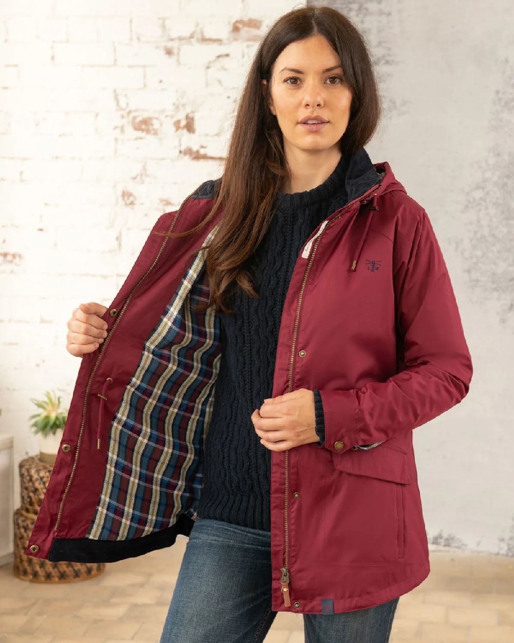 Berry coloured Lighthouse Kendal Waterproof Coat on wall background 