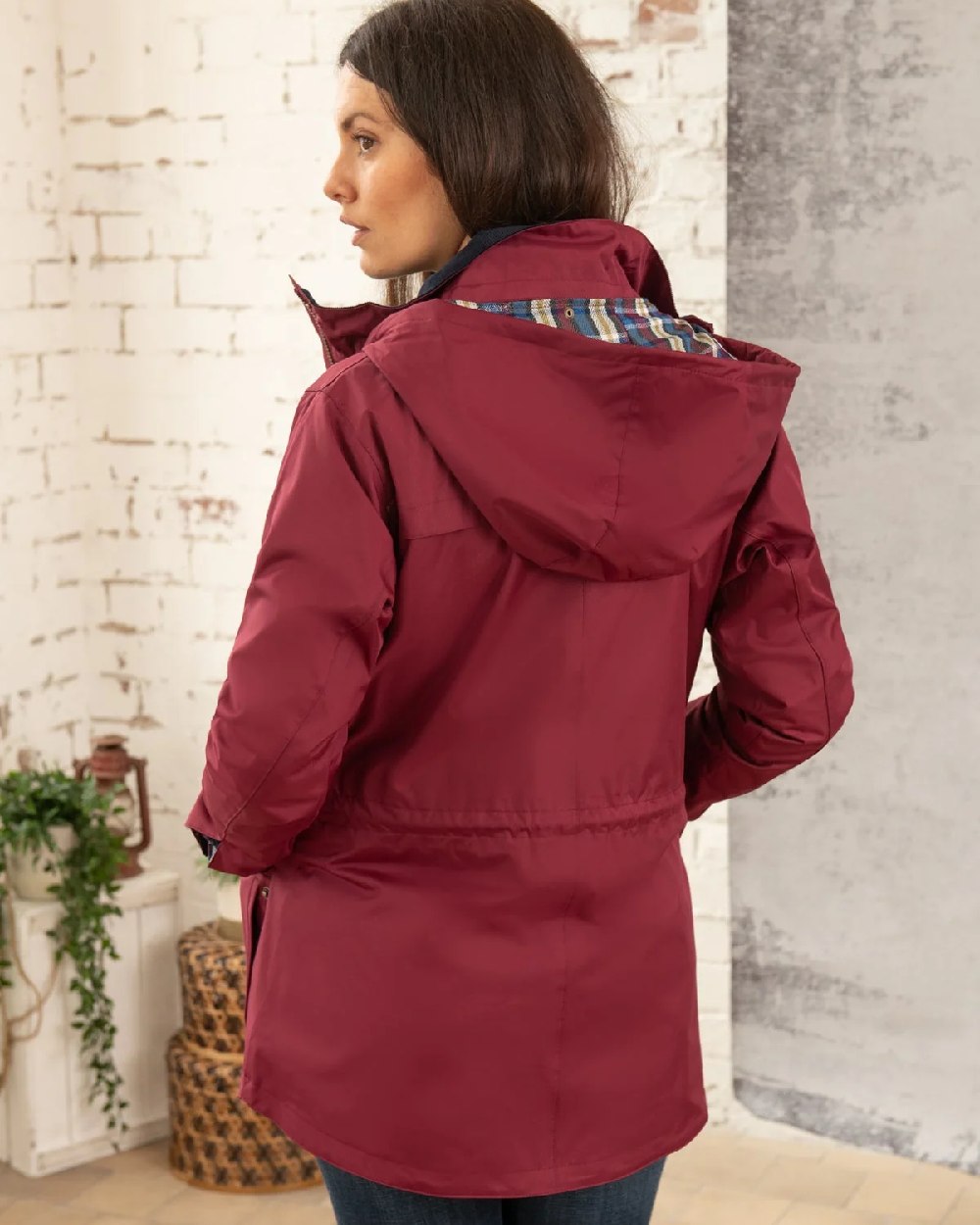 Berry coloured Lighthouse Kendal Waterproof Coat on wall background 