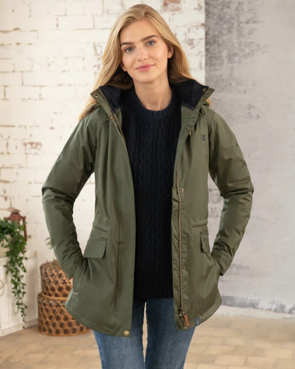 Forest coloured Lighthouse Kendal Waterproof Coat on wall background 