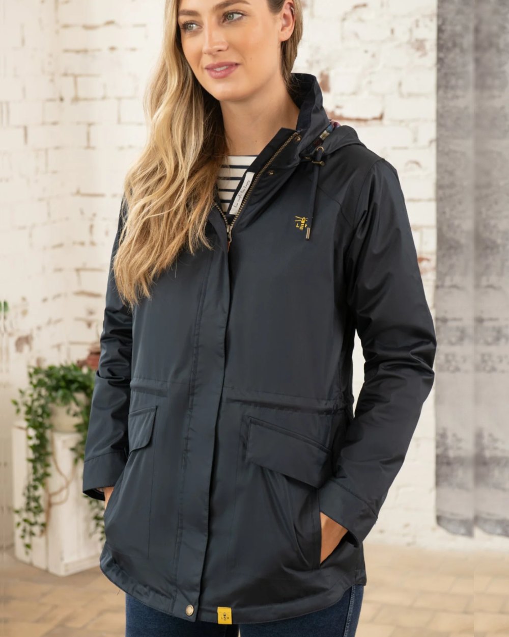 Nightshade coloured Lighthouse Kendal Waterproof Coat on wall background 