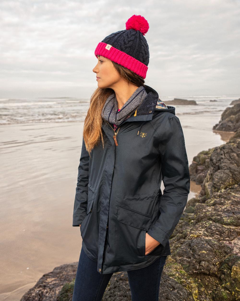 Nightshade coloured Lighthouse Kendal Waterproof Coat on beach background 