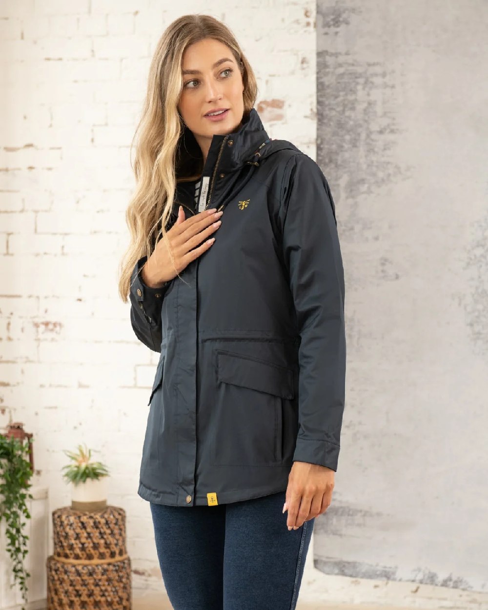 Nightshade coloured Lighthouse Kendal Waterproof Coat on wall background 