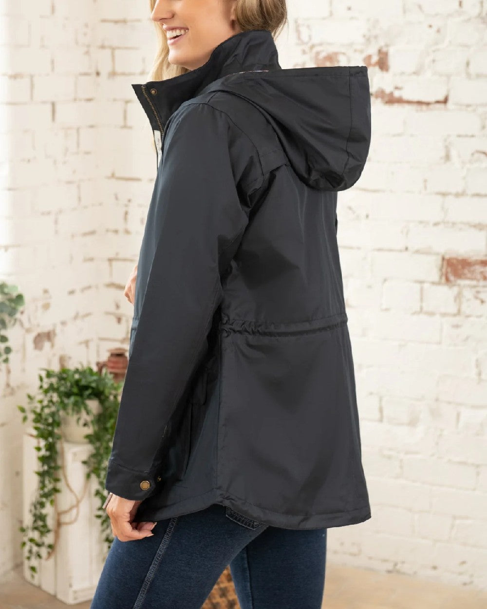 Nightshade coloured Lighthouse Kendal Waterproof Coat on wall background 