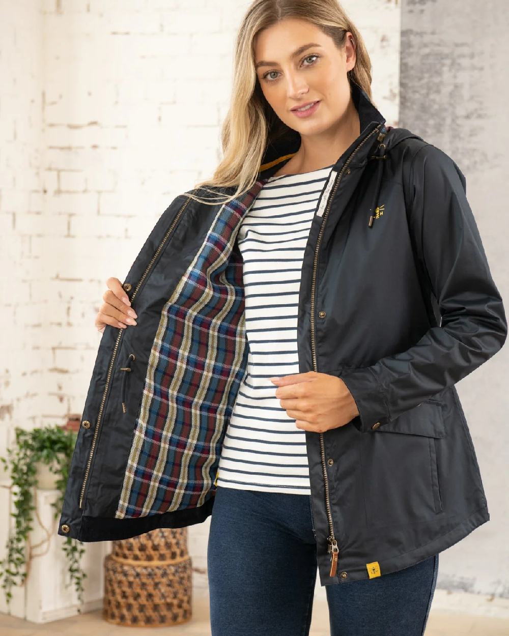 Nightshade coloured Lighthouse Kendal Waterproof Coat on wall background 