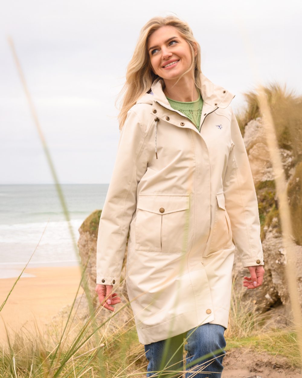 Cream coloured Lighthouse Ladies Annika Coat on coastal background 