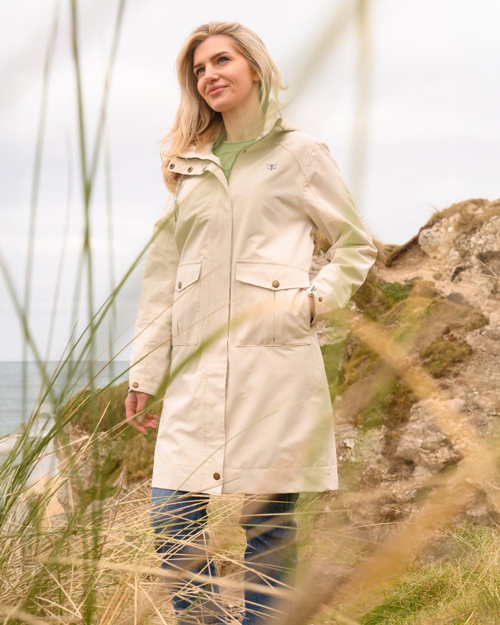 Cream coloured Lighthouse Ladies Annika Coat on coastal background 