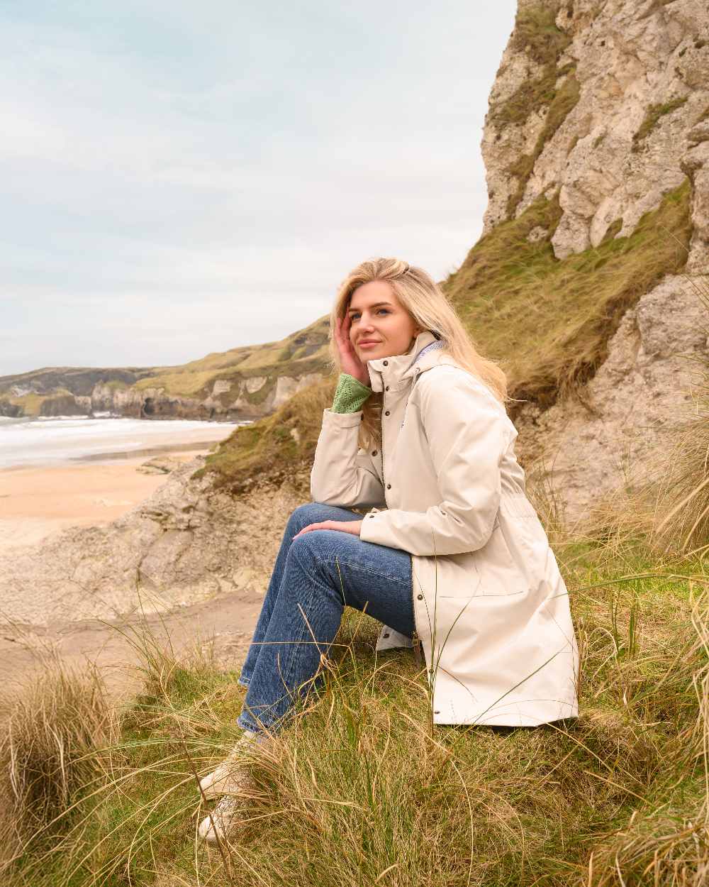 Cream coloured Lighthouse Ladies Annika Coat on coastal background 