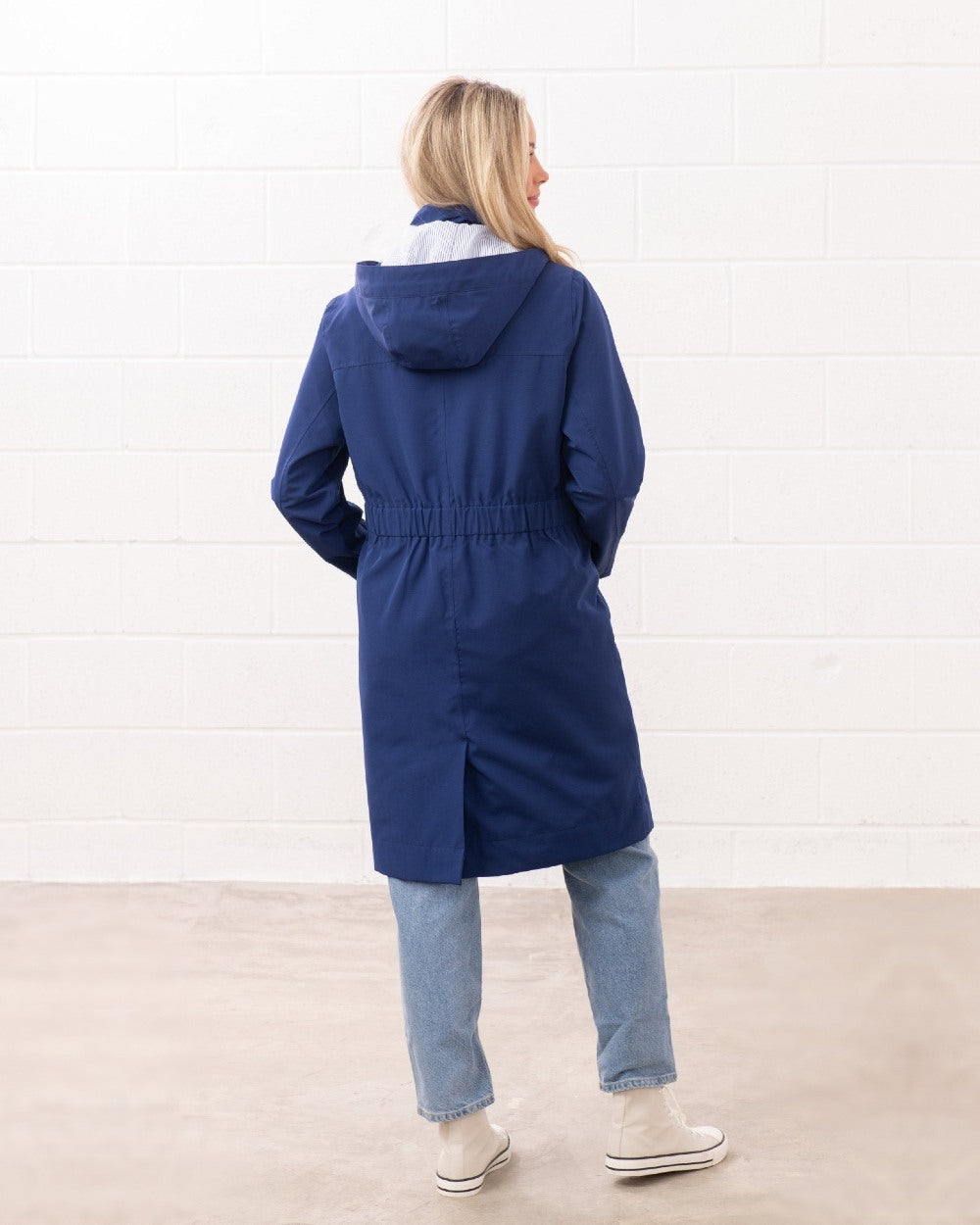 Indigo coloured Lighthouse Ladies Annika Coat on wall background 