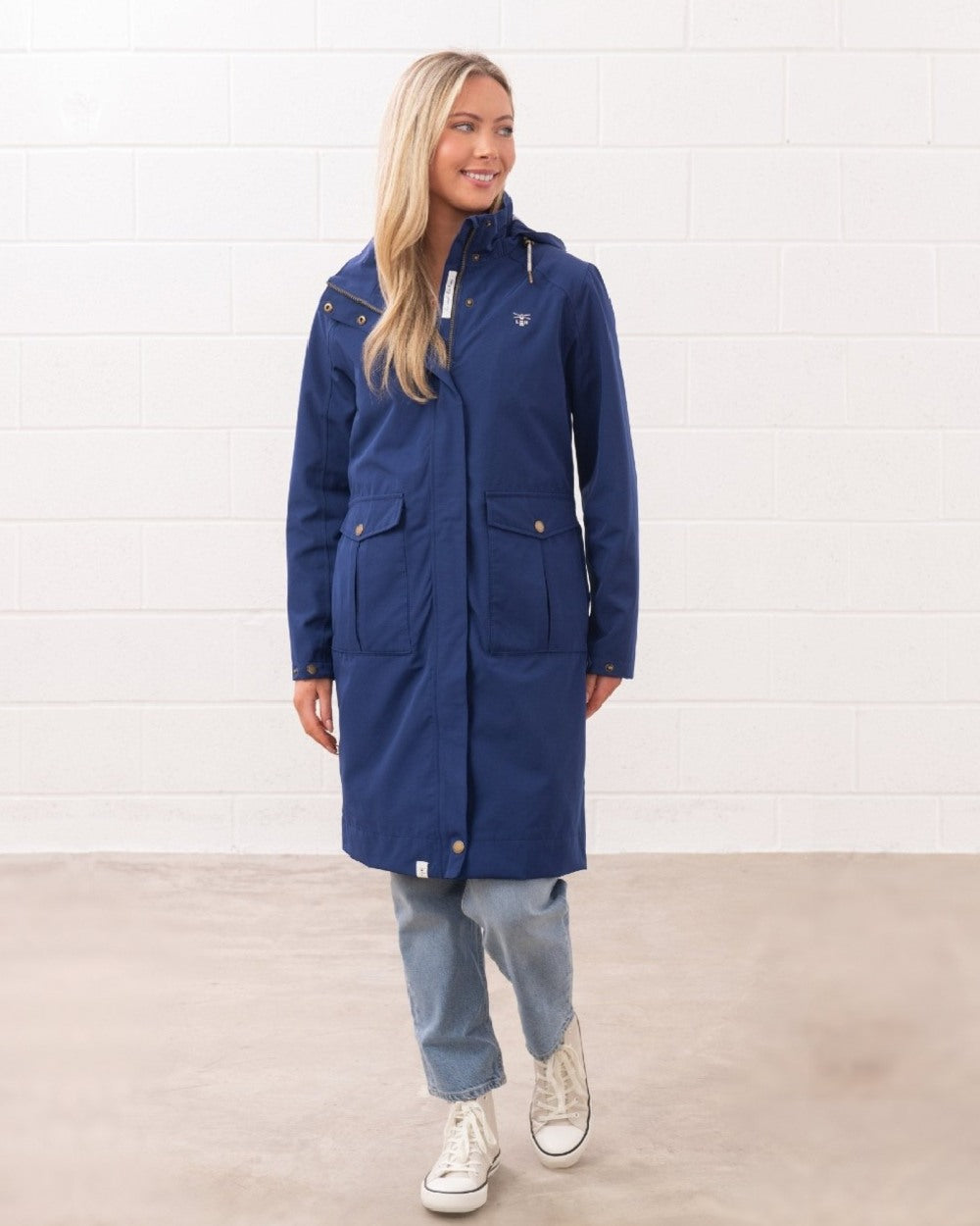 Indigo coloured Lighthouse Ladies Annika Coat on wall background 