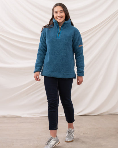 Teal coloured Lighthouse Ladies Coast Half Zip Fleece Sweater on curtain background 