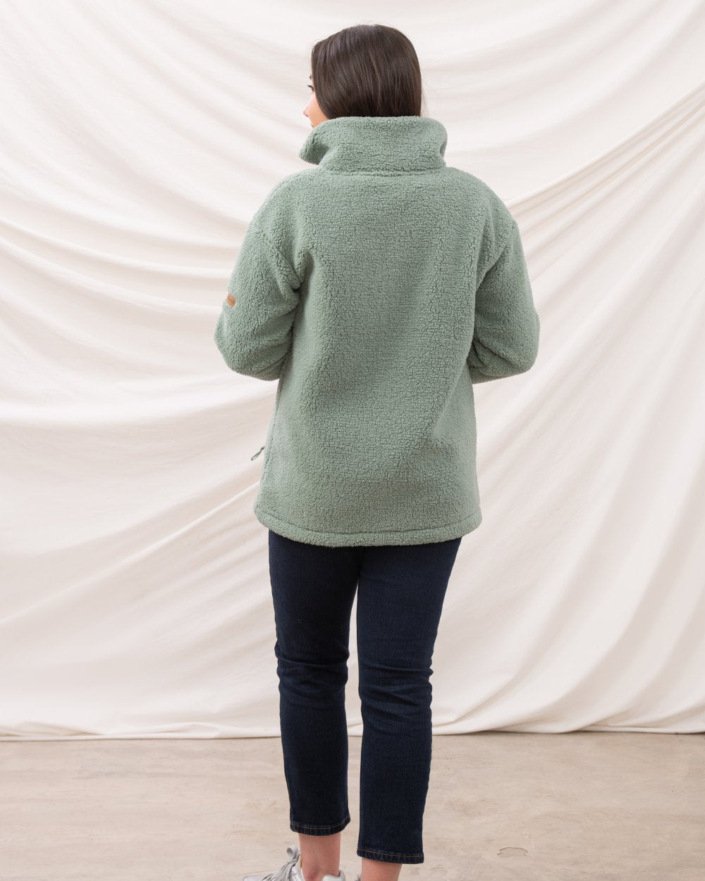 Sage coloured Lighthouse Ladies Cobh Full Zip Fleece Jacket on curtain background 