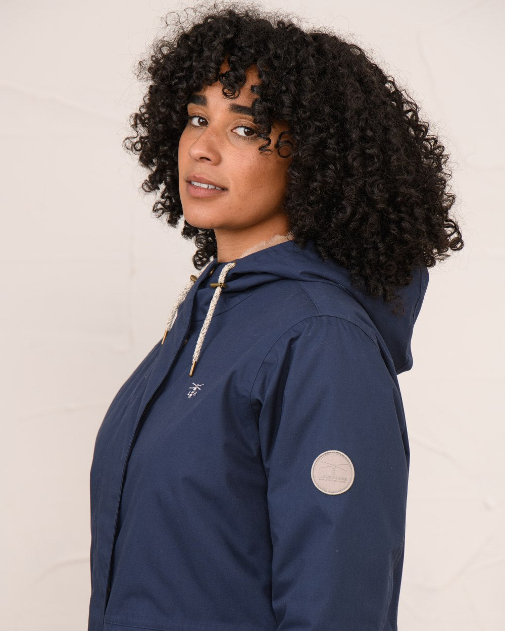 Navy coloured Lighthouse Ladies Fallon Coat on wall background 