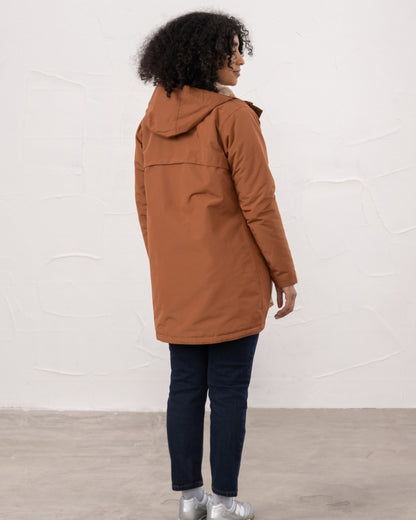 Rust coloured Lighthouse Ladies Scarlet Coat on wall background 