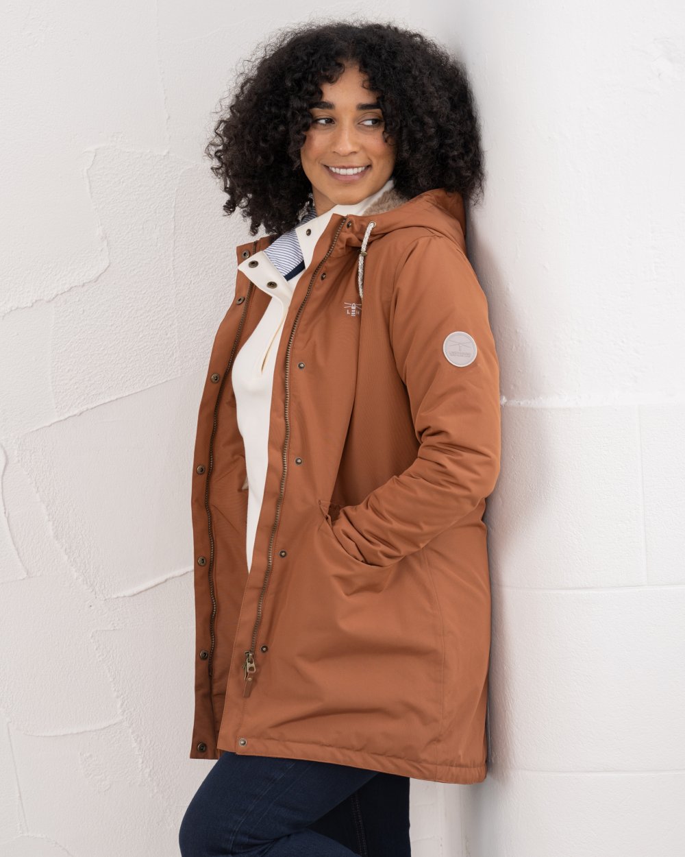 Rust coloured Lighthouse Ladies Scarlet Coat on wall background 