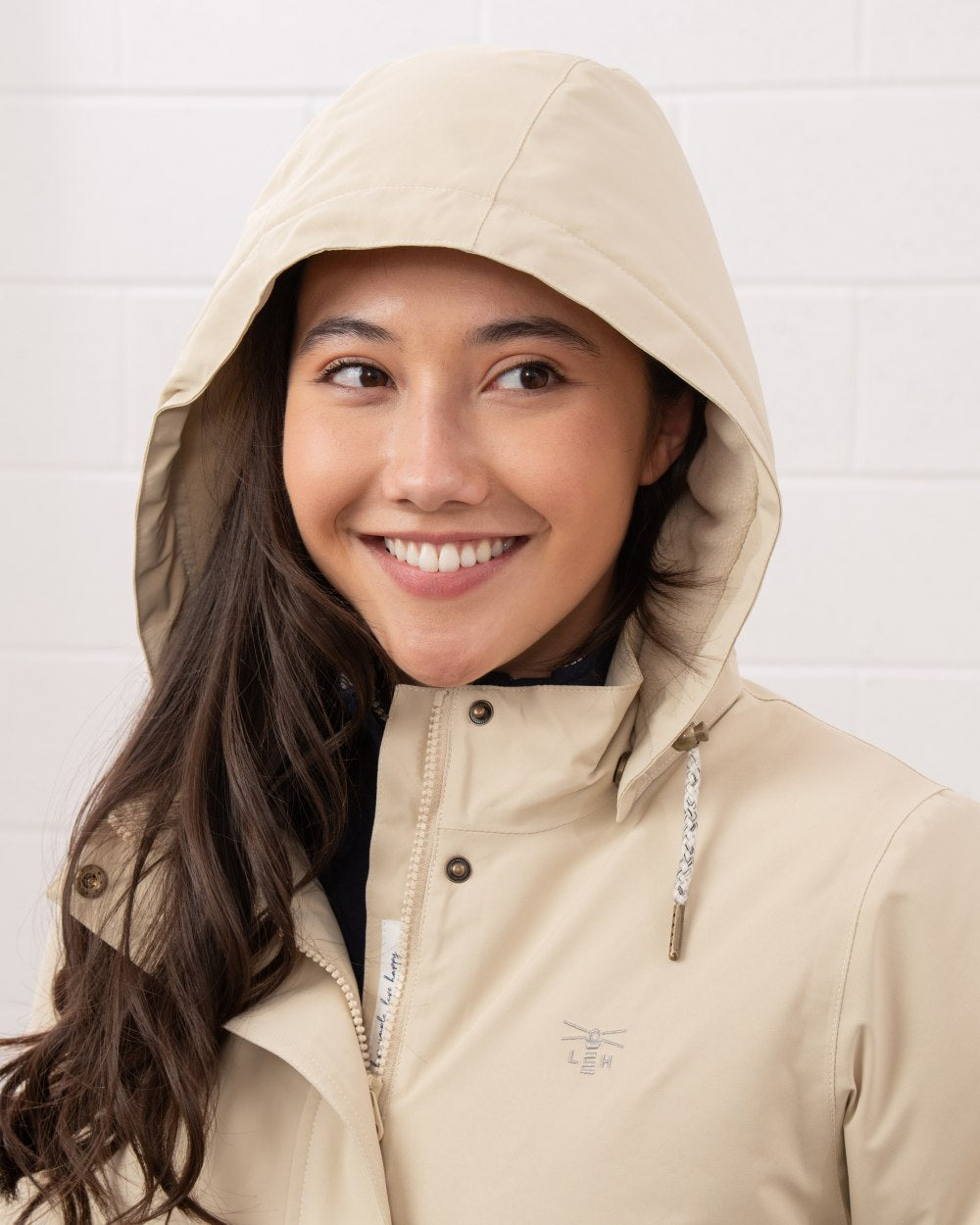 Cream coloured Lighthouse Ladies Tess Coat on wall background 