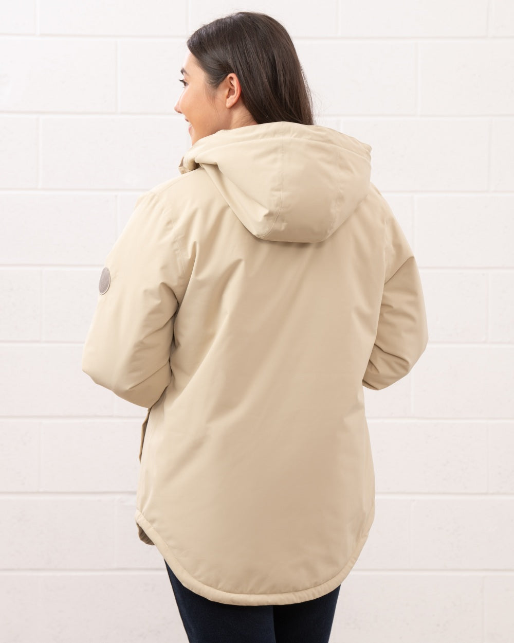 Cream coloured Lighthouse Ladies Tess Coat on wall background 
