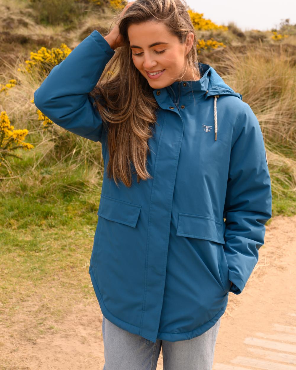 Teal coloured Lighthouse Ladies Tess Coat on grassy background 