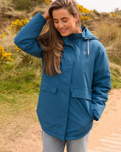 Teal coloured Lighthouse Ladies Tess Coat on grassy background 