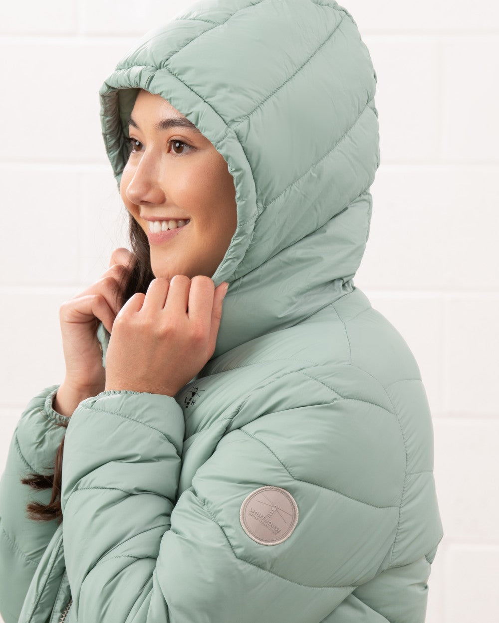 Sage coloured Lighthouse Laurel Ladies Coat on wall background 