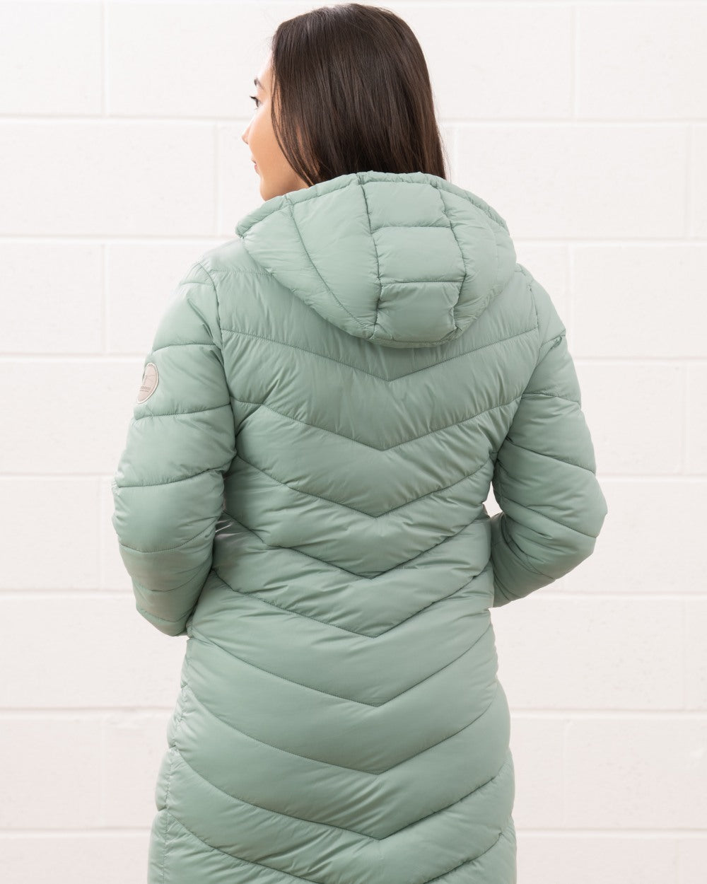 Sage coloured Lighthouse Laurel Ladies Coat on wall background 