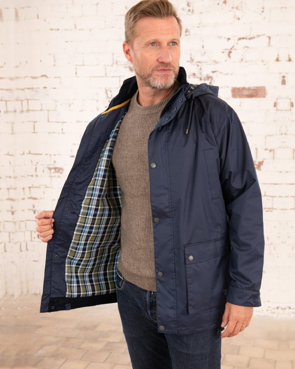 Navy coloured Lighthouse Mens Oxford Raincoat on wall background 