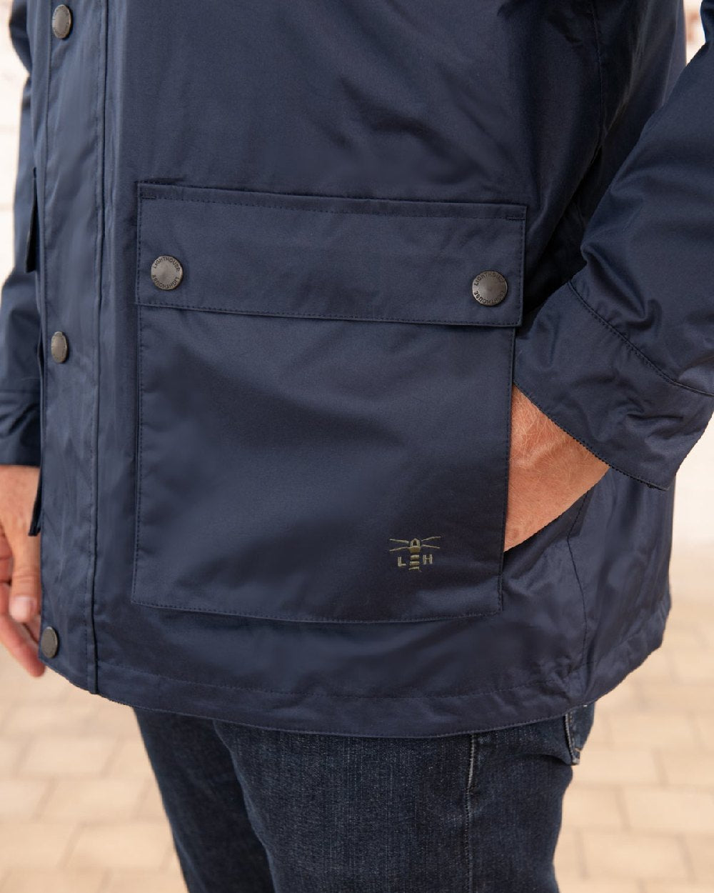 Navy coloured Lighthouse Mens Oxford Raincoat on wall background 