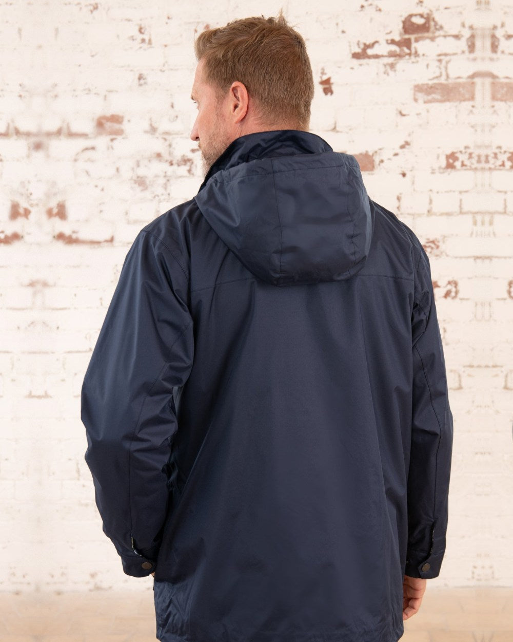 Navy coloured Lighthouse Mens Oxford Raincoat on wall background 