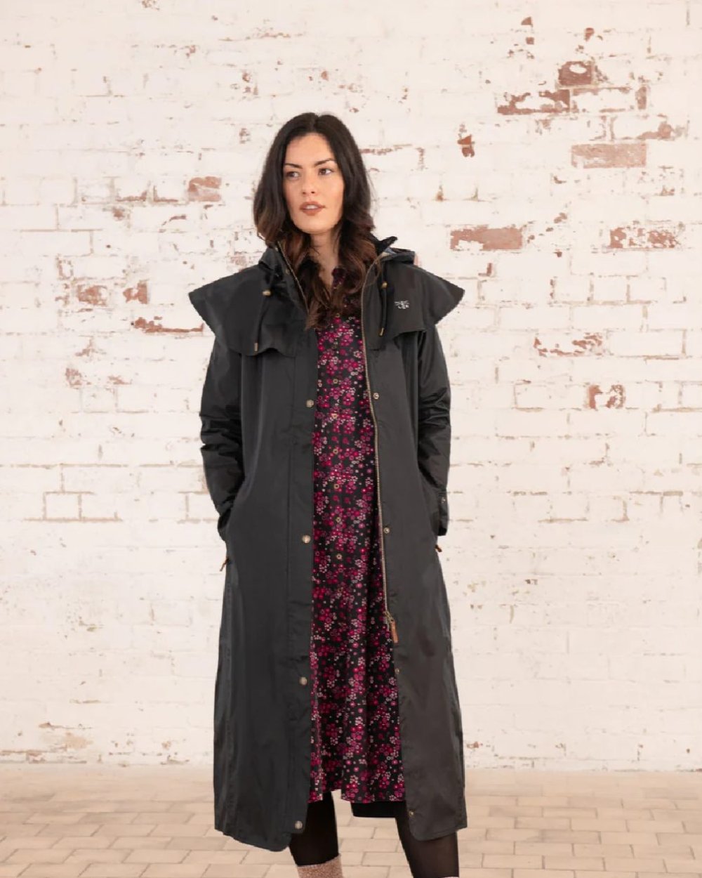 Black coloured Lighthouse Outback Full Length Ladies Waterproof Raincoat on wall background 