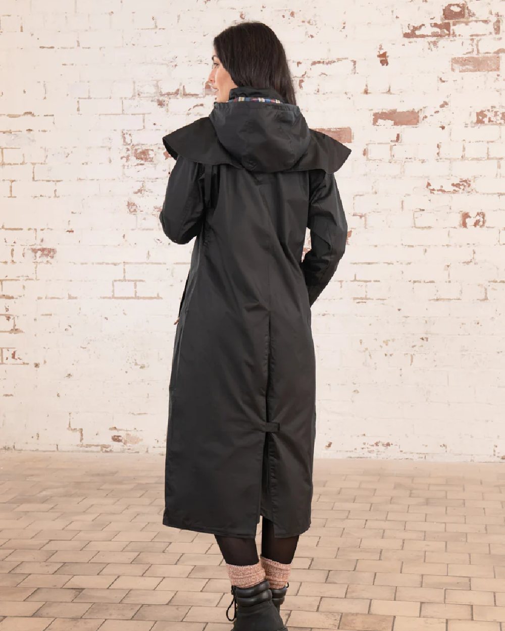 Black coloured Lighthouse Outback Full Length Ladies Waterproof Raincoat on wall background 