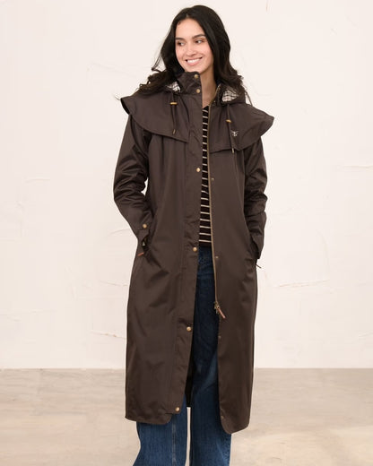 Chocolate coloured Lighthouse Outback Full Length Ladies Waterproof Raincoat on wall background 