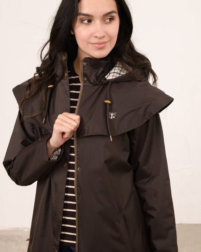 Chocolate coloured Lighthouse Outback Full Length Ladies Waterproof Raincoat on wall background 
