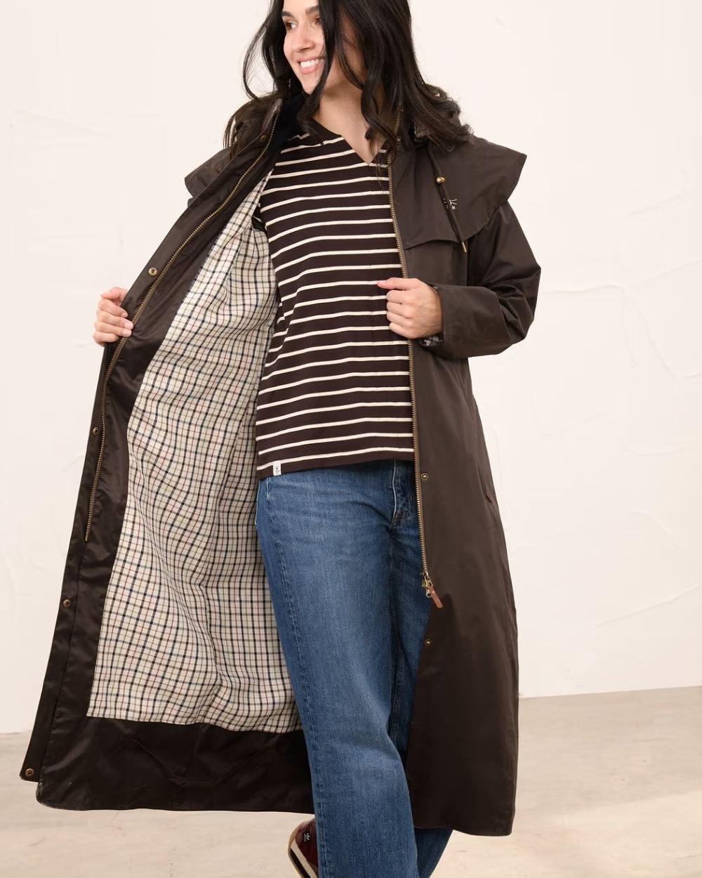 Chocolate coloured Lighthouse Outback Full Length Ladies Waterproof Raincoat on wall background 