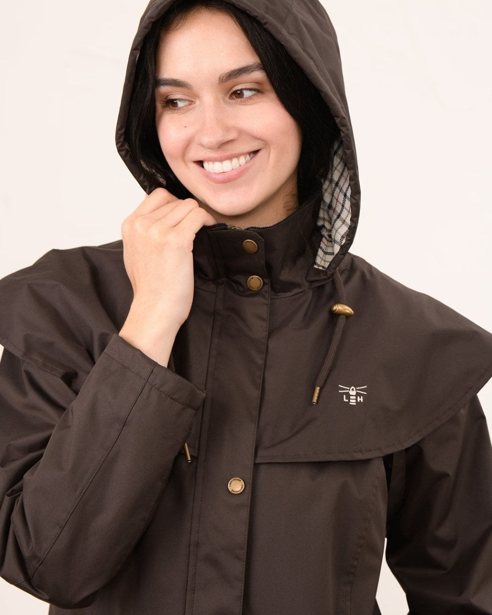 Chocolate coloured Lighthouse Outback Full Length Ladies Waterproof Raincoat on wall background 