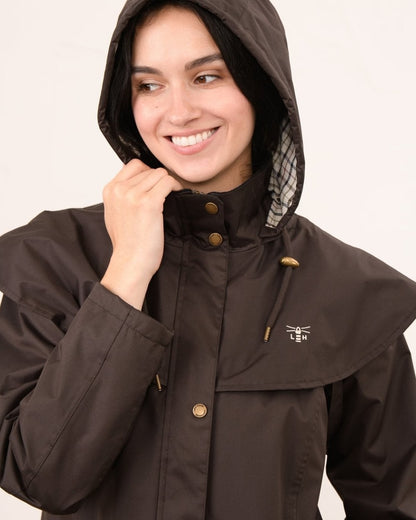 Chocolate coloured Lighthouse Outback Full Length Ladies Waterproof Raincoat on wall background 