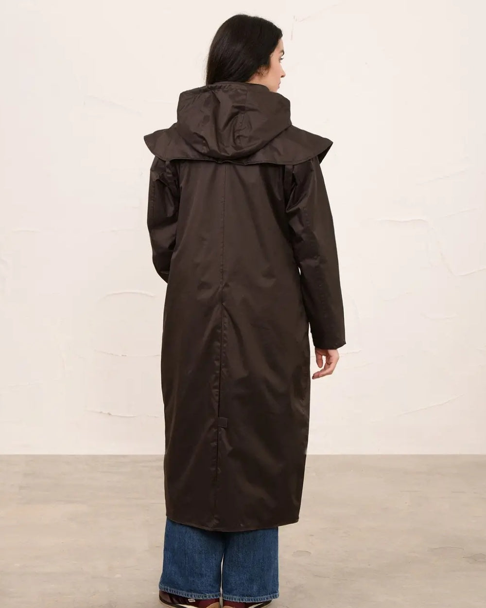 Chocolate coloured Lighthouse Outback Full Length Ladies Waterproof Raincoat on wall background 