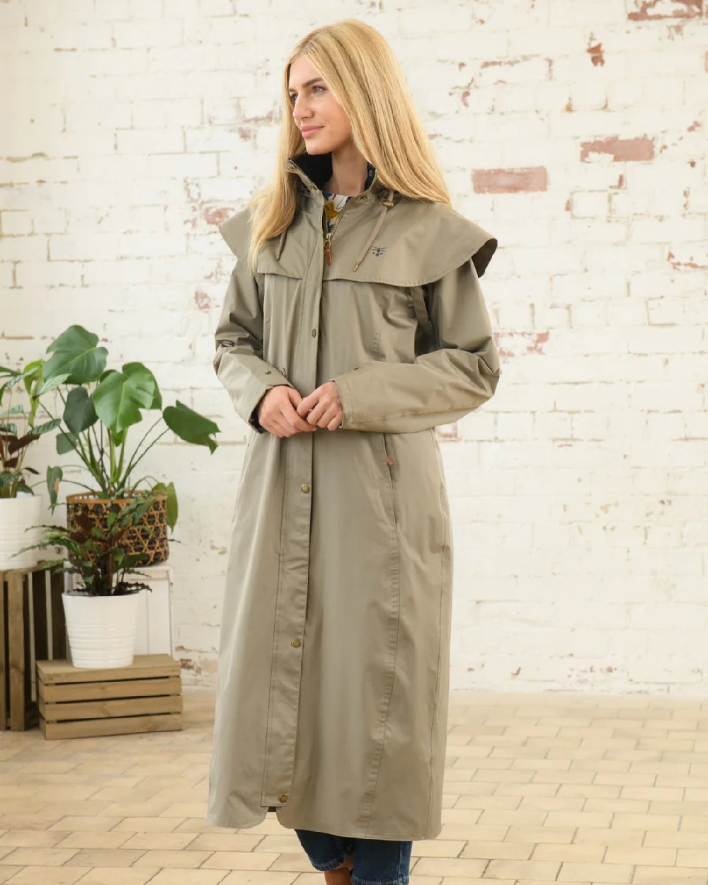 Fawn coloured Lighthouse Outback Full Length Ladies Waterproof Raincoat on wall background 