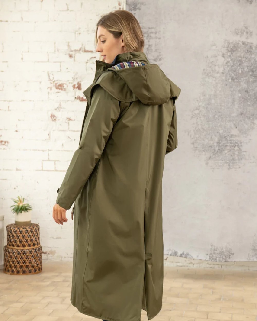 Fern coloured Lighthouse Outback Full Length Ladies Waterproof Raincoat on wall background 