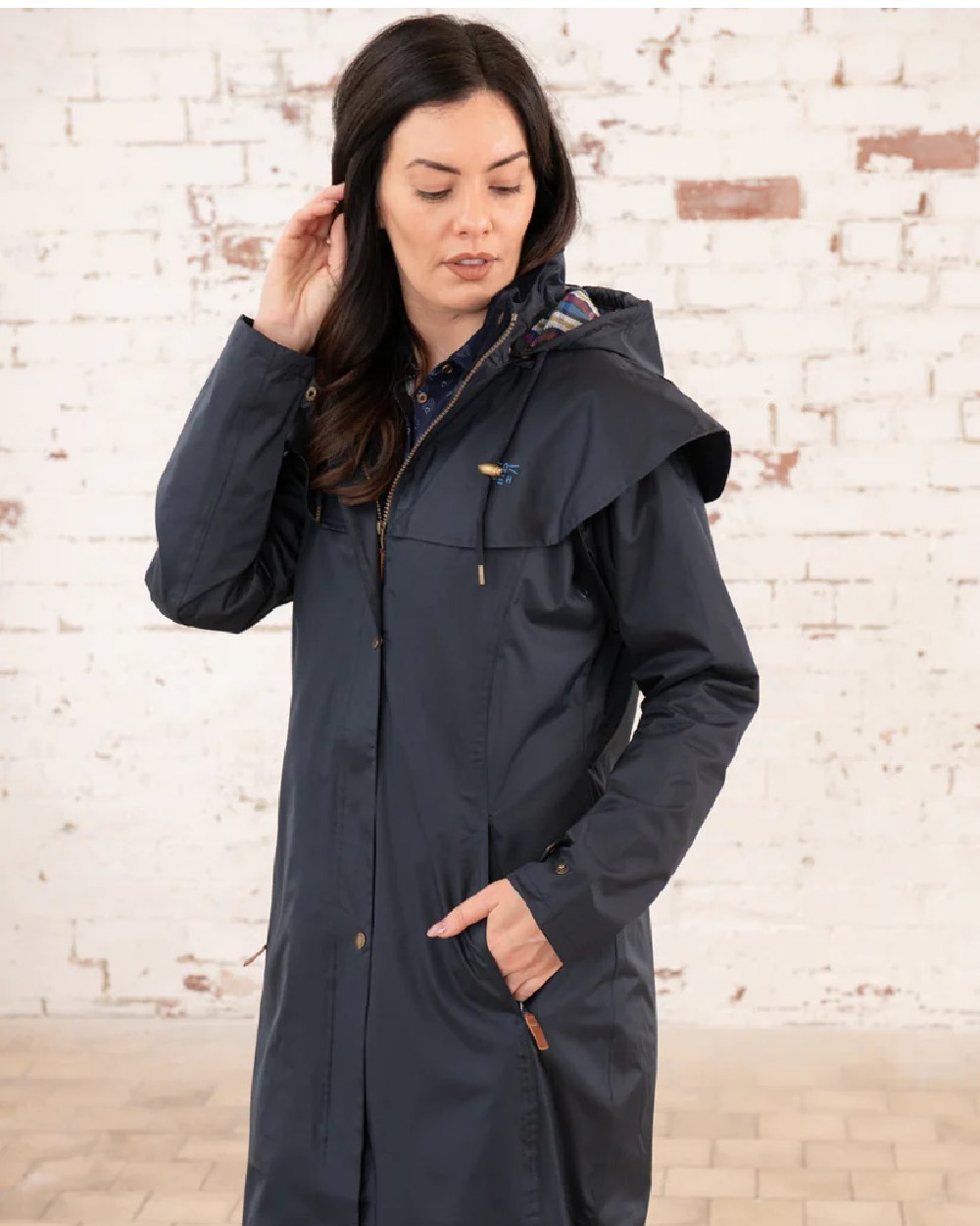 Nightshade coloured Lighthouse Outback Full Length Ladies Waterproof Raincoat on wall background 