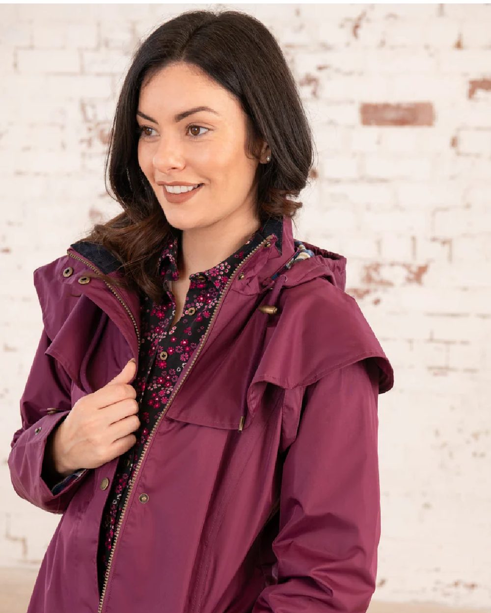 Plum coloured Lighthouse Outback Full Length Ladies Waterproof Raincoat on wall background 