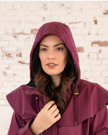 Plum coloured Lighthouse Outback Full Length Ladies Waterproof Raincoat on wall background 