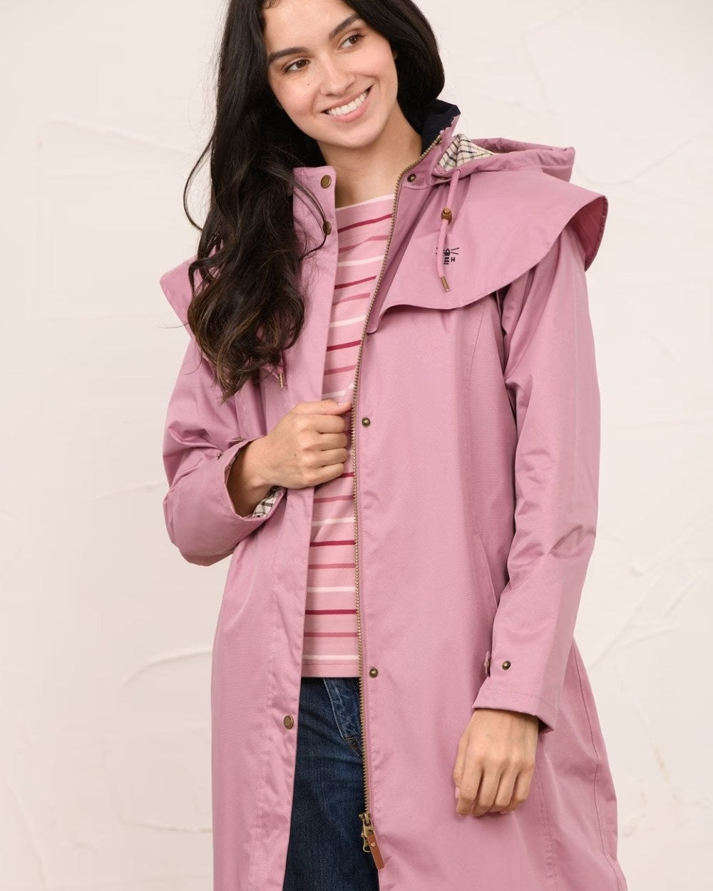 Wild Rose coloured Lighthouse Outback Full Length Ladies Waterproof Raincoat on wall background 