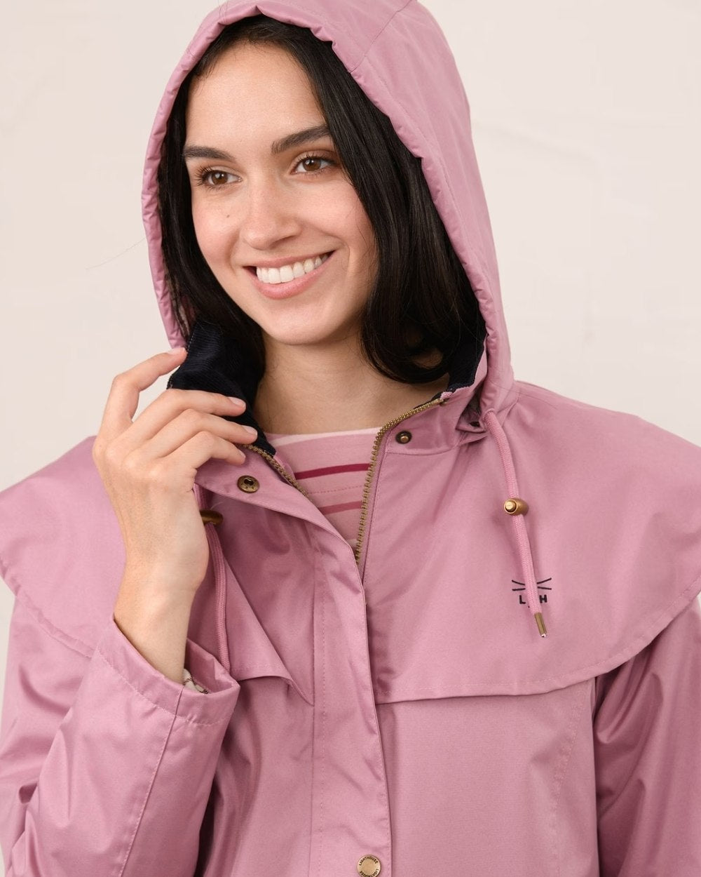Wild Rose coloured Lighthouse Outback Full Length Ladies Waterproof Raincoat on wall background 