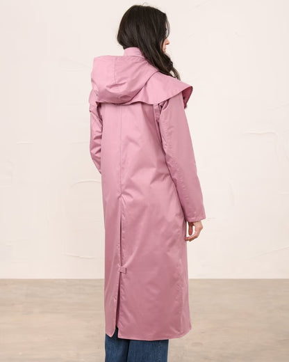 Wild Rose coloured Lighthouse Outback Full Length Ladies Waterproof Raincoat on wall background 