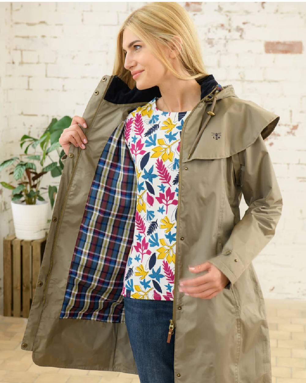 Fawn coloured Lighthouse Outrider 3/4 Length Ladies Waterproof Raincoat on wall background 