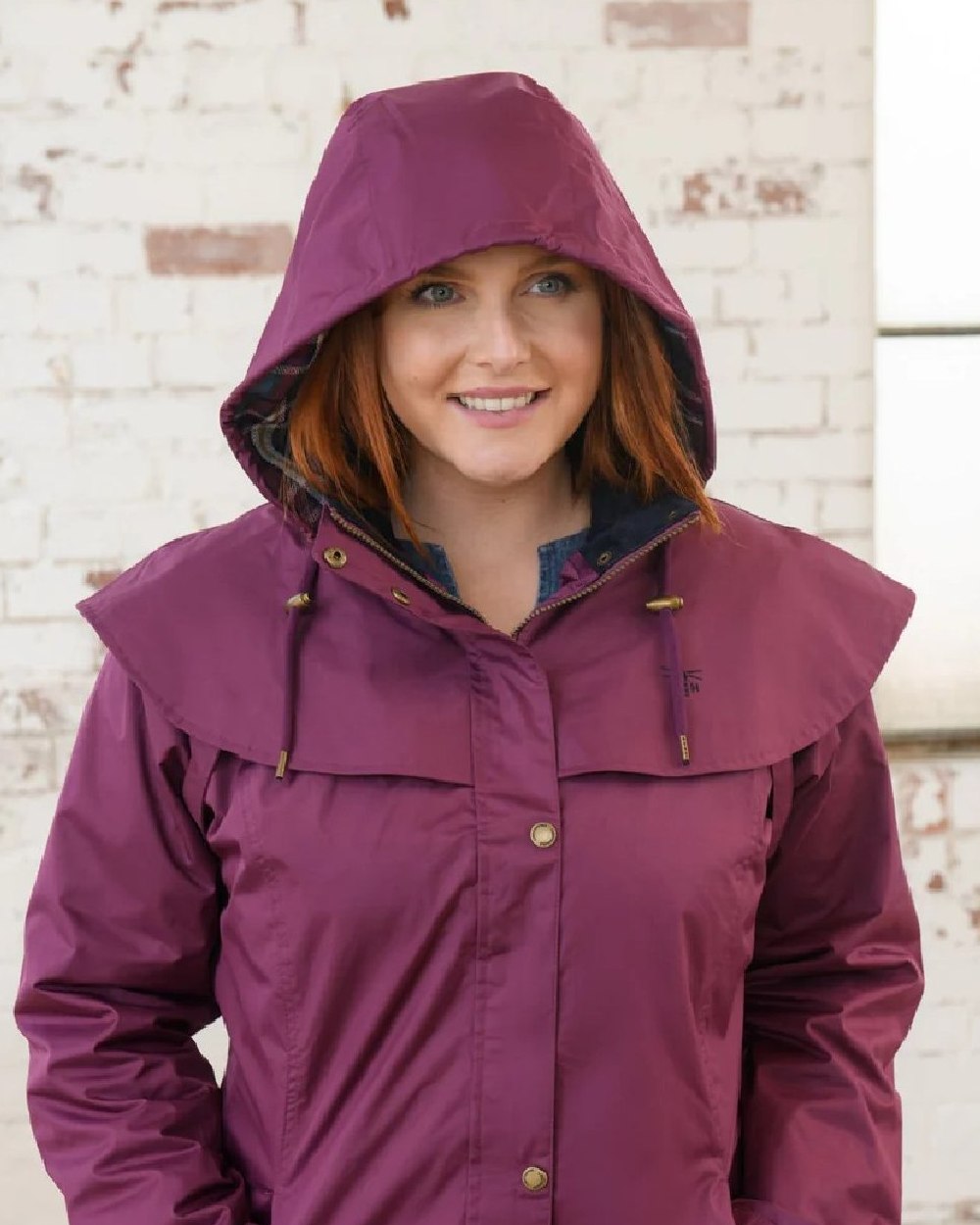 Plum coloured Lighthouse Outrider 3/4 Length Ladies Waterproof Raincoat on wall background 