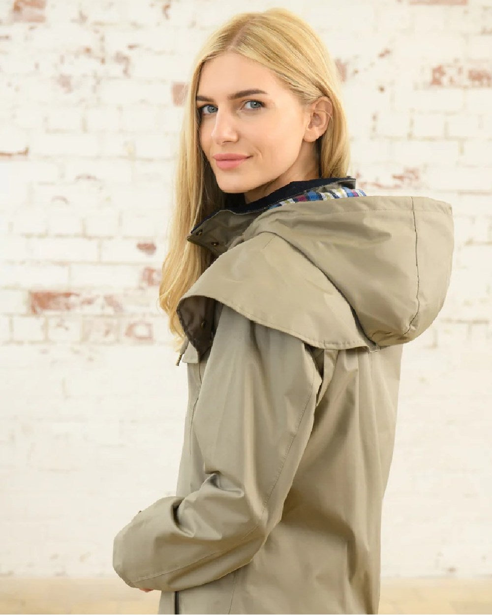 Fawn coloured Lighthouse Outrider 3/4 Length Ladies Waterproof Raincoat on wall background 