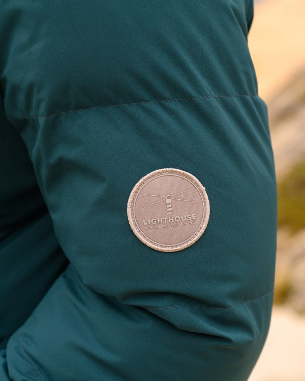Pine coloured Lighthouse Savannah Coat on beach background 